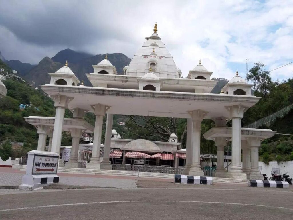 Main entrance gate of Vaishno Devi Temple in Katra during Vaishno Devi Yatra, with white marble structure and scenic mountain backdrop.